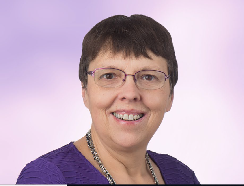 Dr. Christine Sauer smiling, wearing a purple top